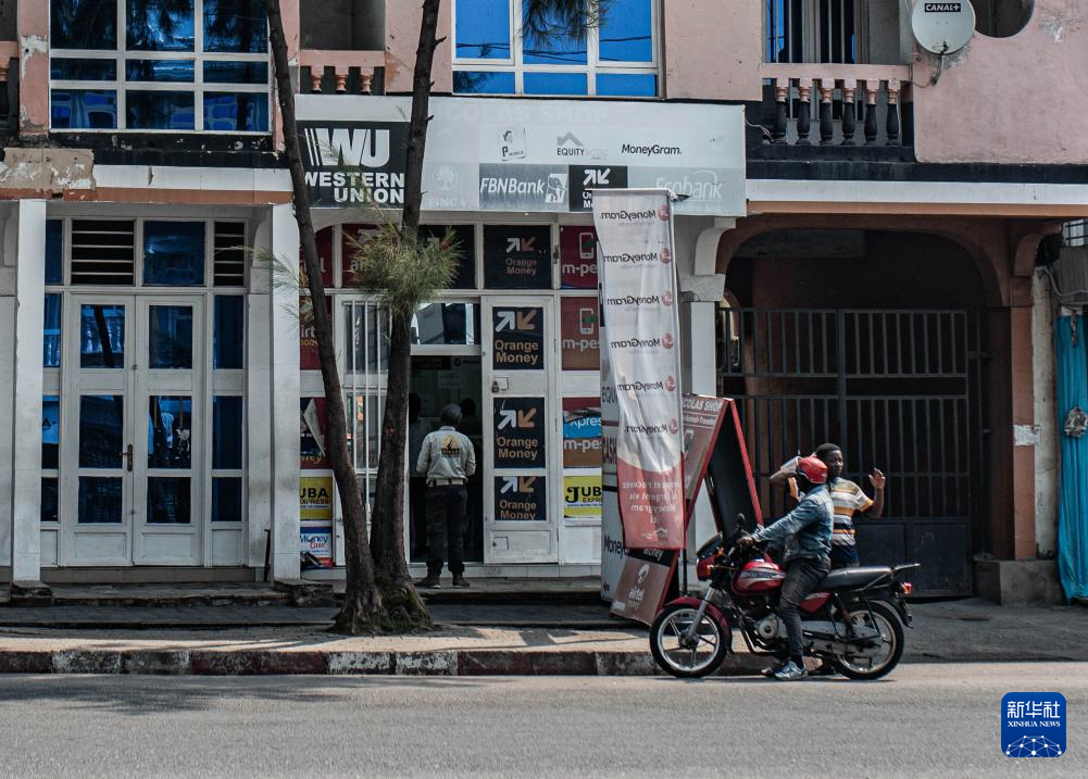 1月27日，在刚果（金）北基伍省首府戈马市，人们在一处汇款网点外停留。新华社发