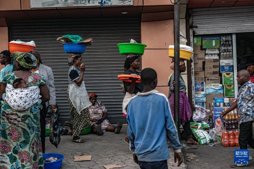 1月27日，在刚果（金）北基伍省首府戈马市，人们经过一处商铺。新华社发