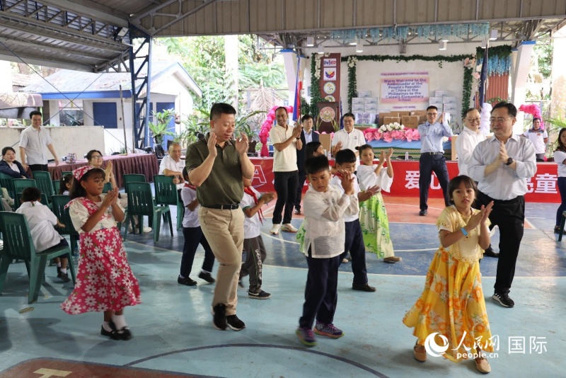井泉大使等中方代表与加拉威斯小学学生一起跳起当地舞蹈。人民网记者樊帆 摄