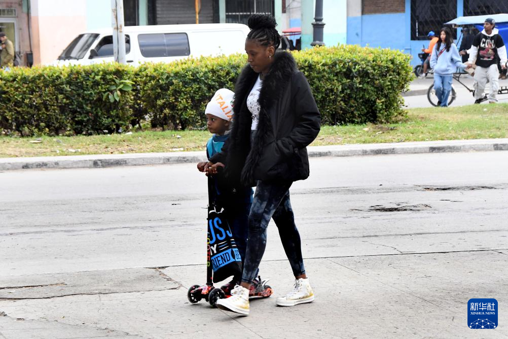 　2月3日，在古巴首都哈瓦那，当地民众穿着长袖外套走在街头。