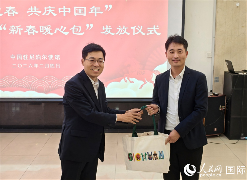 中国驻尼泊尔使馆临时代办周攀为在尼侨胞发放“新春暖心包”。人民网记者 李墨摄