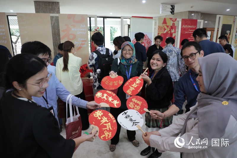 现场观众展示亲手制作的书法扇作品。人民网记者 曹师韵摄