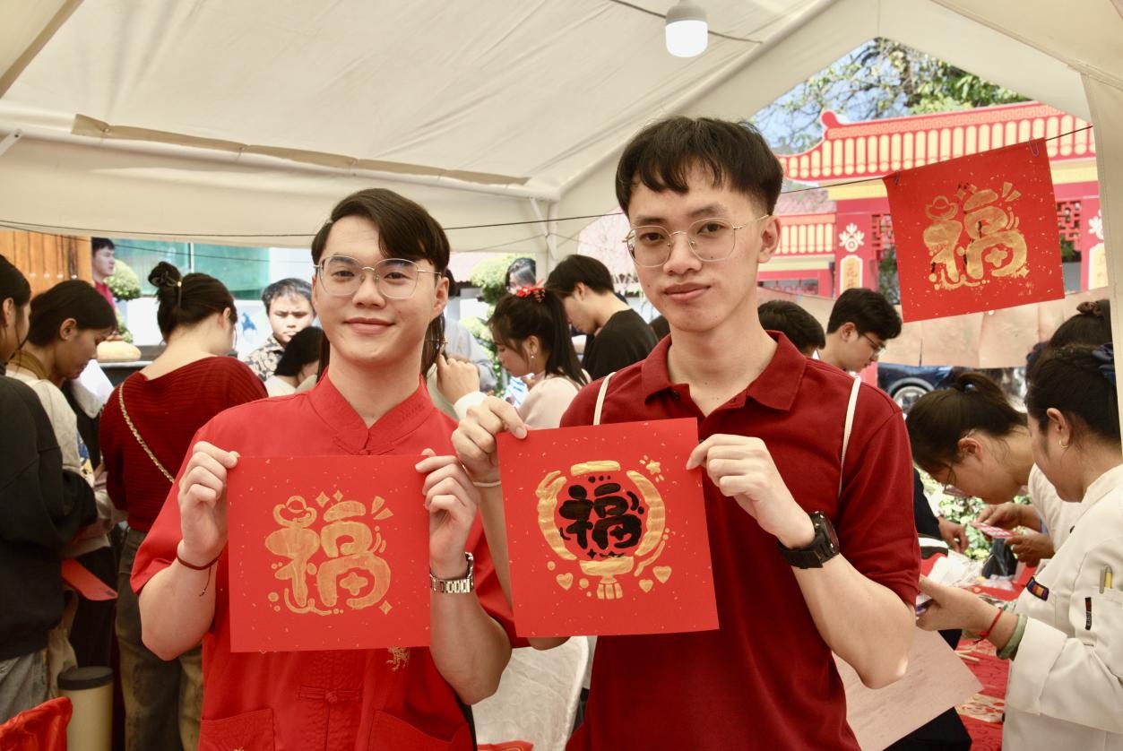 当地学生在庙会现场展示自己制作的“福”字。苏朋摄