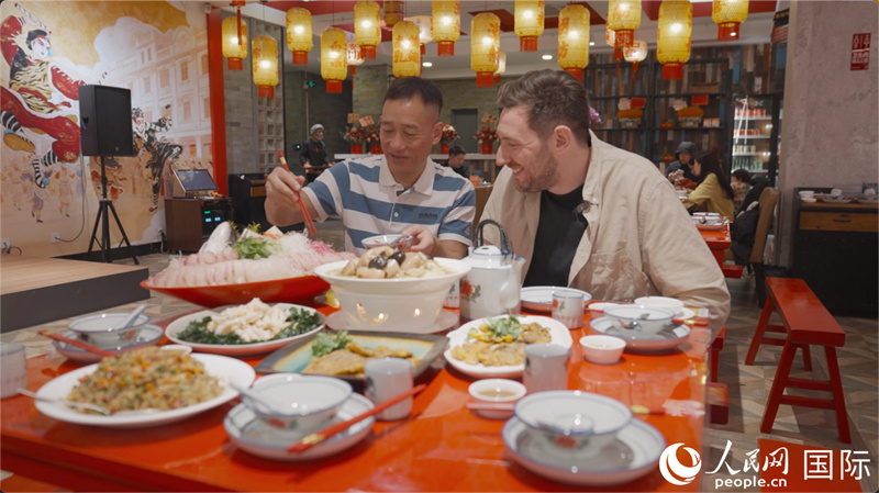 广东汕头,人民网外专柯明可与陈志毅师傅(左一)在潮舫英歌宴餐厅品尝他们制作的菜肴。人民网记者 刘宁摄