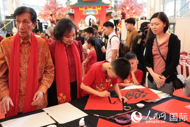 当地民众体验中国书法,现场书写“福”字。人民网记者 曹师韵摄