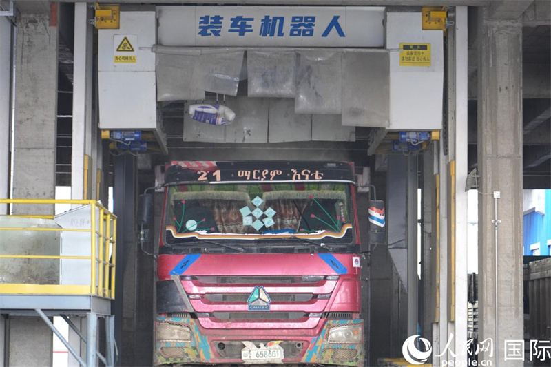 水泥厂使用装车机器人为卡车装载水泥。人民网记者 黄炜鑫摄