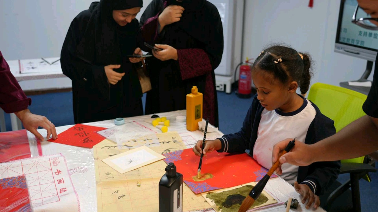当地青少年在文化展示与互动体验活动中体验中国书法。沙特智慧宫中文教育学院供图