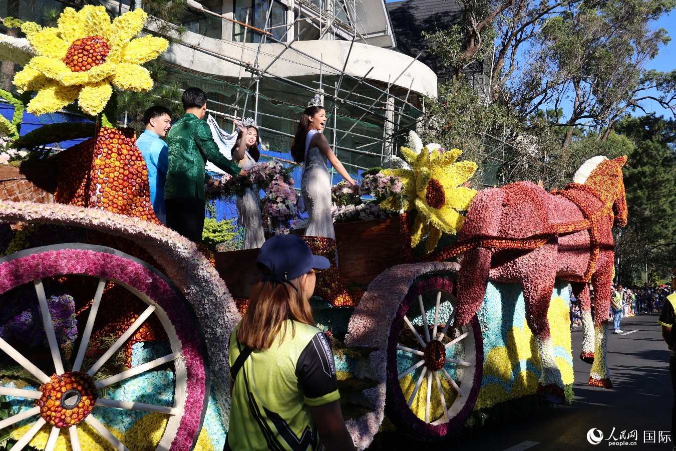 碧瑶市政府骏马造型花车上的表演者与沿途观众热情互动。人民网记者 樊帆摄