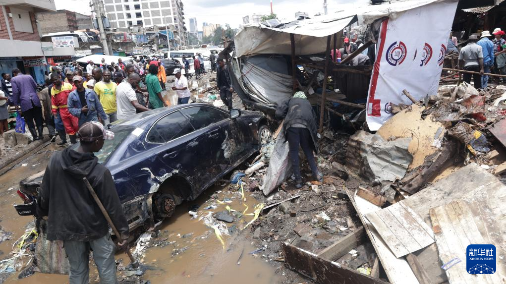 3月7日，在肯尼亚首都内罗毕，人们清理洪水过后的街道。新华社发（约翰·奥科约摄）