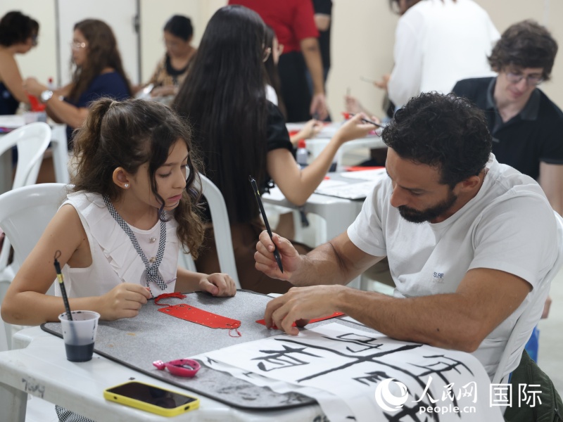 活动参与者在中国文化体验课程中体验中国书法。人民网记者  时元皓摄