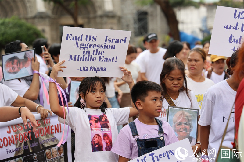 游行队伍中一名菲律宾儿童举着呼吁中东地区停火的标语牌。人民网记者 樊帆摄
