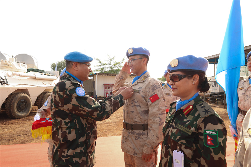 联阿安全部队特派团代理团长兼部队司令为官兵佩戴勋章。韩瑞田摄