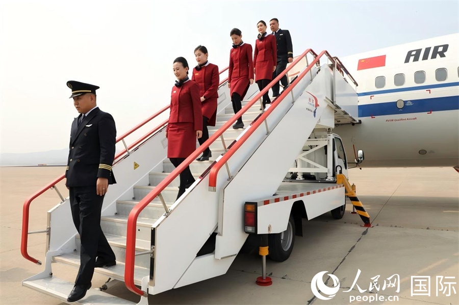 国航CA121号航班机组工作人员走下飞机舷梯。 人民网记者 刘融摄
