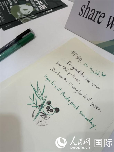 图片展现场的观众留言册上，海外民众积极评论打卡并画下了生动活泼的熊猫手绘。 人民网记者 张矜若摄