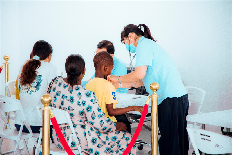 援外医疗队员对当地儿童患者问诊。坦桑尼亚东非商贸物流中心供图