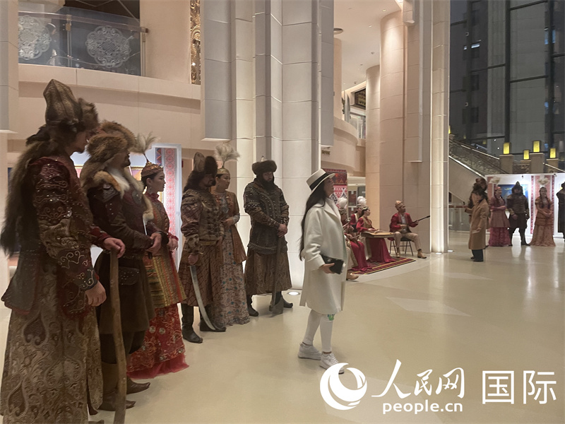 观众与展示哈萨克斯坦民族服装的模特合影。人民网记者 曲颂摄