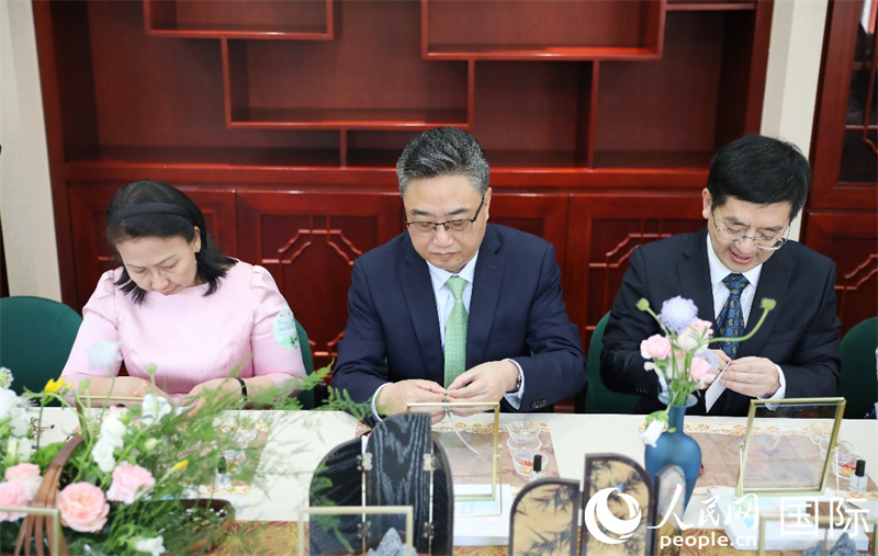 嘉宾参与金丝宝石画宋锦小马，从左至右分别为柬埔寨驻华大使宋嘉薇，中国—东盟中心秘书长史忠俊与北京市对外友协党组书记、常务副会长王禹。人民网 王婧摄