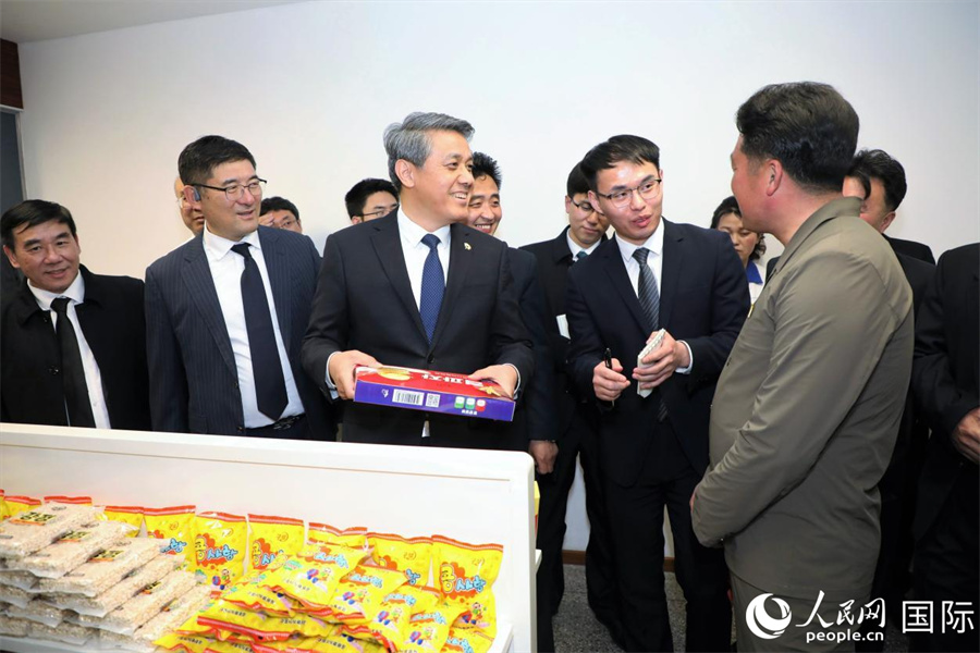 龟城市食品厂总工程师李赫向中方介绍该厂生产的饼干等点心。人民网记者 刘融摄