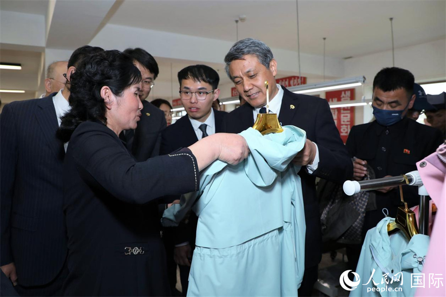 龟城市服装厂经理金英姬向中方一行介绍该厂制作的成衣。人民网记者 刘融摄