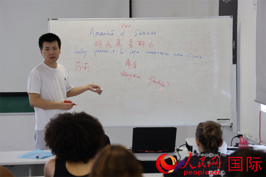 4月2日是国际儿童图书日，巴西里约热内卢北部的曼吉尼奥斯芭蕾舞社区学校开展了一场别具特色的阅读活动，其中中文阅读成为一大亮点。图为里约热内卢天主教大学孔子学院青年教师张德君正在为中文实验班的学生们讲授中文基础知识。 人民网实习生 侯天泽摄