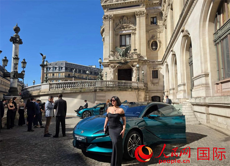 社交平台博主与展陈于歌剧院旁腾势Z9GT车型合影。人民网记者 尚凯元摄