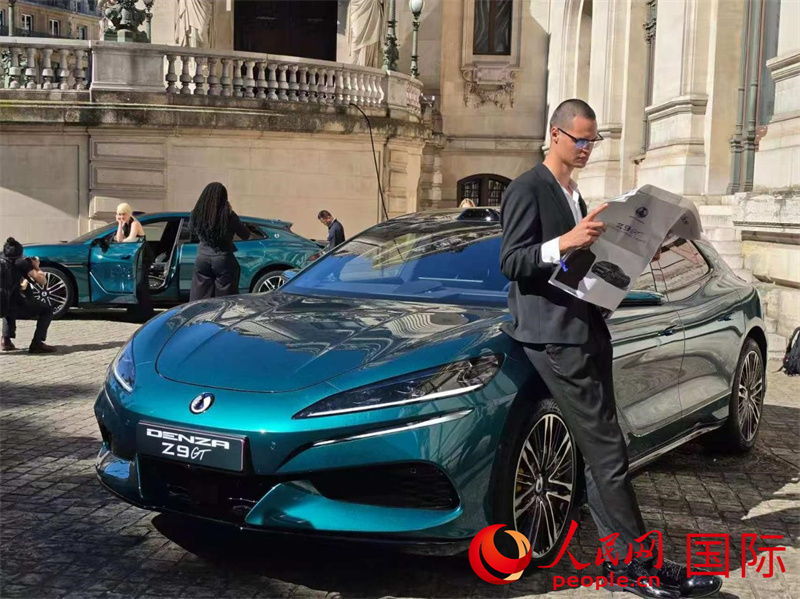 社交平台博主与展陈于歌剧院旁腾势Z9GT车型合影。人民网记者 尚凯元摄