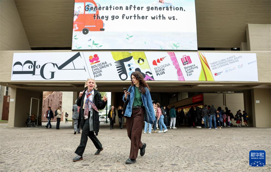 4月13日，在意大利博洛尼亚举行的博洛尼亚国际童书展上，观众从展会主题海报前走过。新华社记者 王楷焱 摄