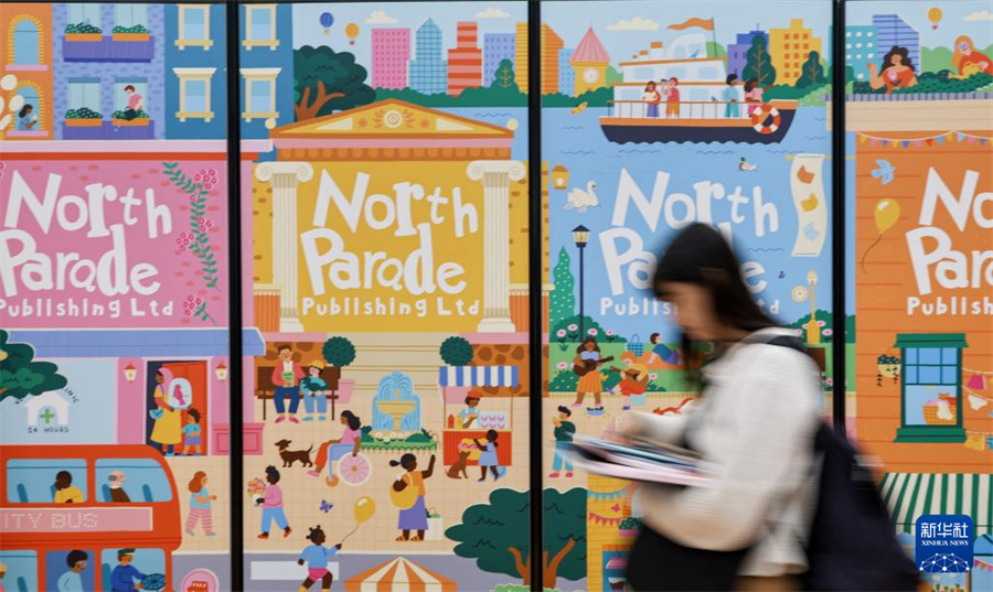 4月13日，在意大利博洛尼亚举行的博洛尼亚国际童书展上，观众从展会主题装饰墙前走过。新华社记者 王楷焱 摄