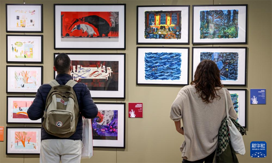 4月13日，在意大利博洛尼亚举行的博洛尼亚国际童书展上，观众欣赏插画作品。新华社记者 王楷焱 摄