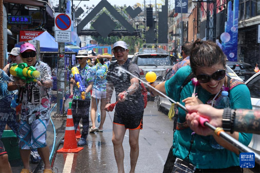 4月13日，人们在泰国清迈街头参加泼水节庆祝活动。新华社记者 孙玮彤 摄