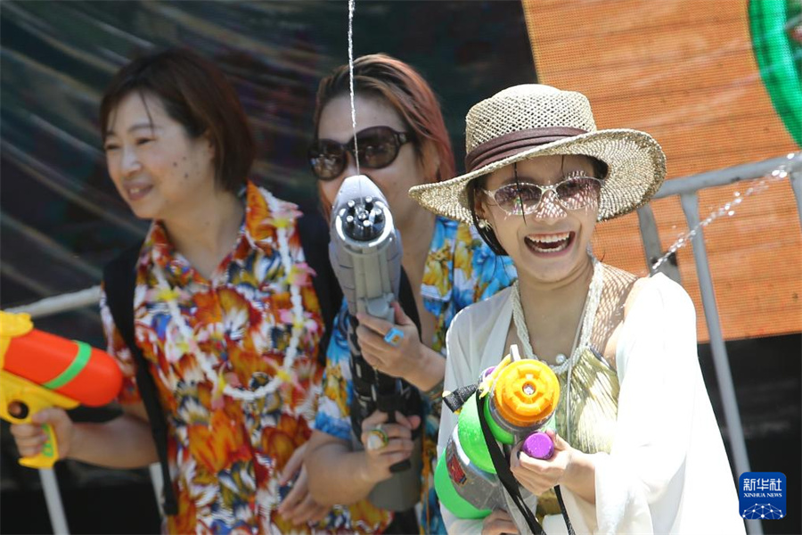 4月13日，人们在泰国曼谷街头参加泼水节庆祝活动。新华社发（拉亨摄）