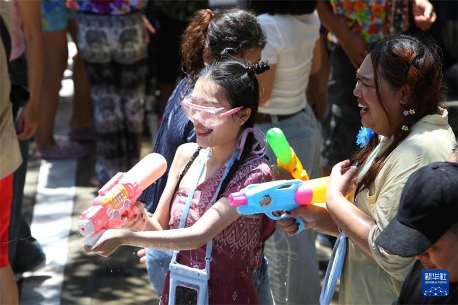 4月13日，人们在泰国曼谷街头参加泼水节庆祝活动。新华社发（拉亨摄）