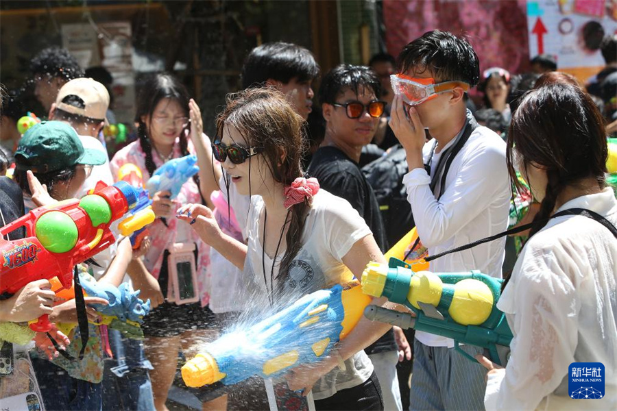 4月13日，人们在泰国曼谷街头参加泼水节庆祝活动。新华社发（拉亨摄）