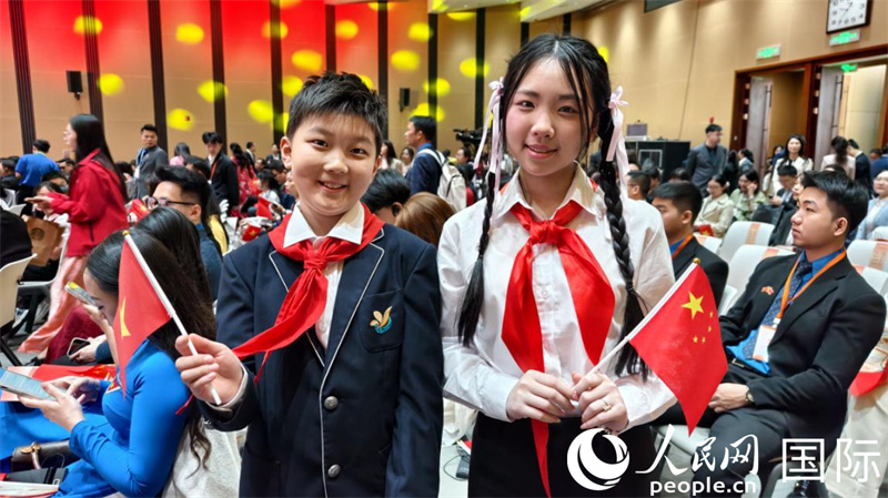 中越两国年龄最小的演讲者手拿对方国家的旗帜，“跨国”合影。人民网记者 刘刚摄