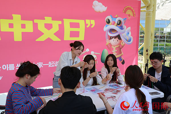 参加文化体验项目的人员学习手工制作中国结。人民网记者 莽九晨摄