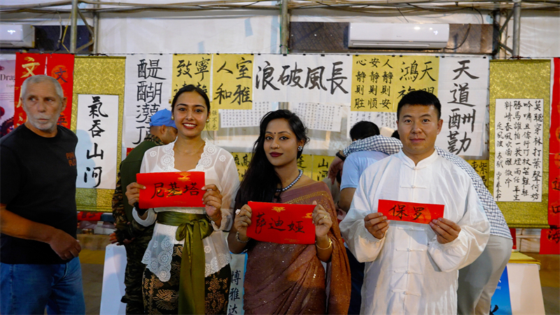 图2说：多国友人体验书法后展示姓名的中文版 黄浩摄