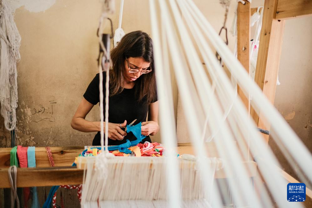 4月21日，在位于埃及开罗“垃圾城”的手工作坊内，工作人员用废旧布料制作手提包。