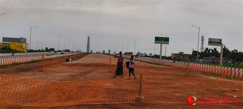 当地民众从BRT施工现场走过 人民网记者 黄培昭摄