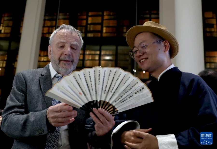 4月24日，在英国伦敦举行的“城市茶客厅”暨“魅力上海”城市形象推广活动上，一名男子欣赏传统中国折扇。新华社记者 李颖 摄