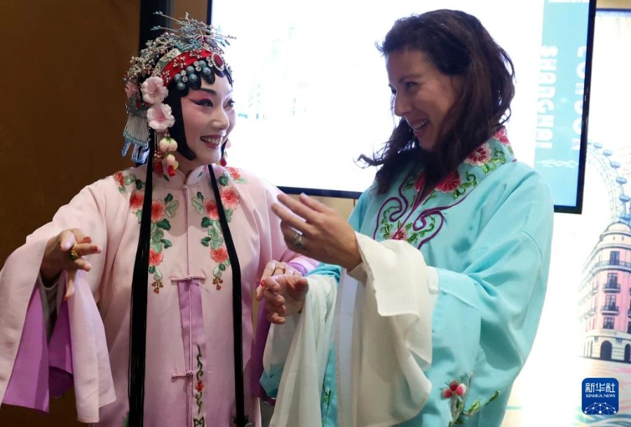 4月24日，在英国伦敦举行的“城市茶客厅”暨“魅力上海”城市形象推广活动上，一名女子与昆曲演员互动。新华社记者 李颖 摄