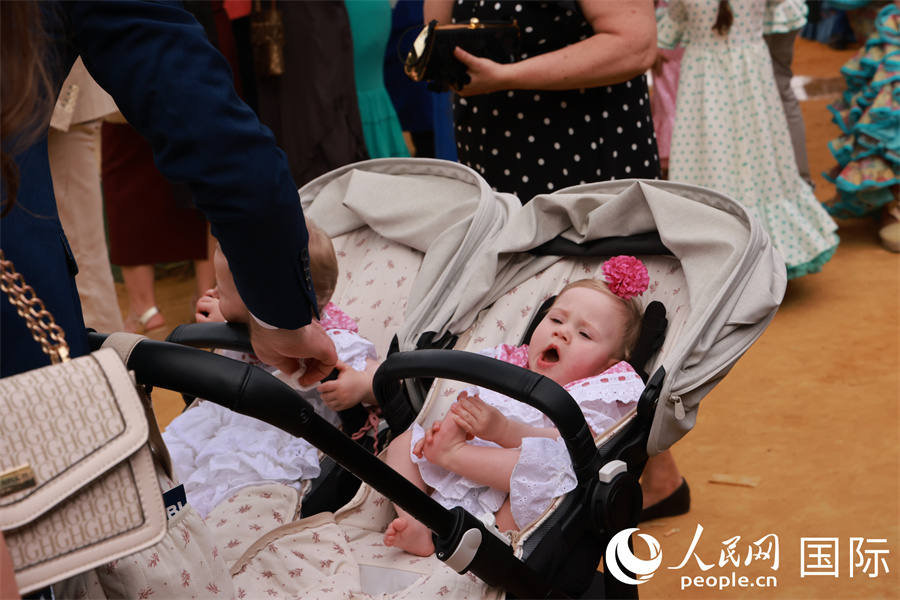 庆典现场不乏推婴儿车出游的家庭，即使婴儿也会盛装打扮。 人民网记者 许海林摄