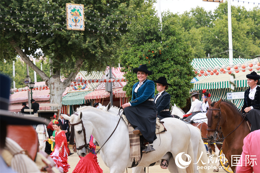 一位身着传统特色短装的女骑手，以独特侧坐姿势纵马参加四月节的“骏马巡游”。 人民网记者 许海林摄