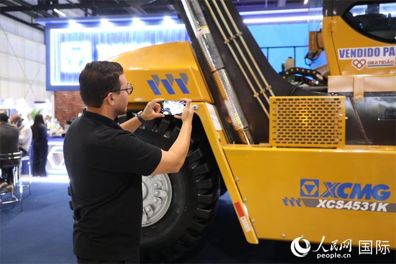 展会现场，一名参观者拍摄徐工集团展出的装备。人民网记者 陈一鸣摄