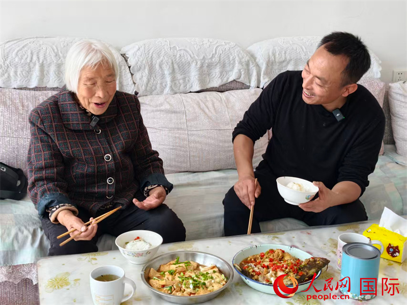李全生（右一）和刁淑芳老人围坐一桌，闲话家常。人民网记者 常沙摄