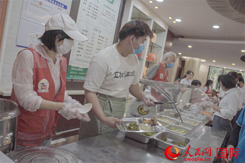 2026年6月12日，志愿者在春江社区幸福助餐点协助为老人打饭。人民网记者 张荣摄