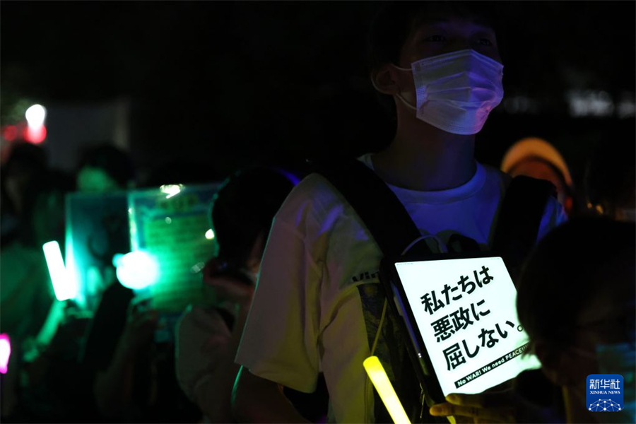 7月10日，在位于日本东京的国会议事堂前，民众手持标语参加抗议集会。新华社记者 岳晨星 摄
