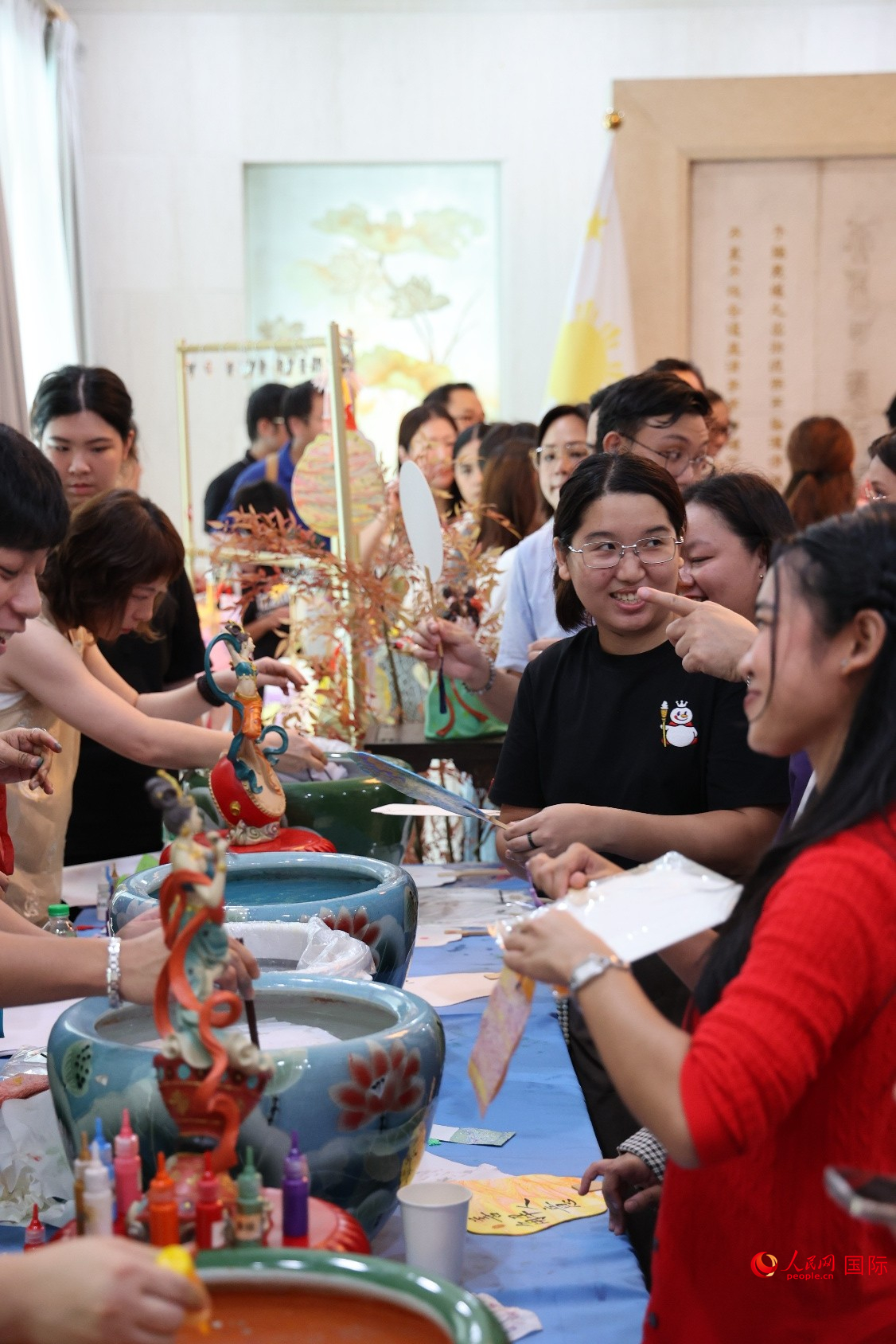 菲律宾民众排队体验中国传统技艺水拓漆扇‌。人民网记者 樊帆摄