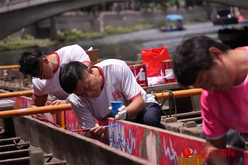 广州猎德村村民正以岭南特色图案为龙舟“画花”。人民网 吴宇扬扬摄