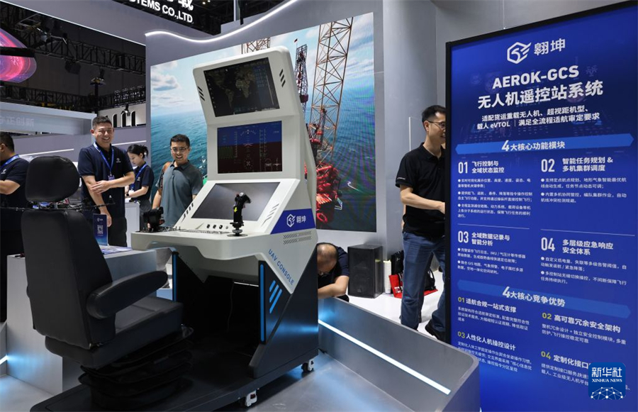 7月22日，参观者在一款无人机遥控站系统展品前交流。新华社记者 方喆 摄