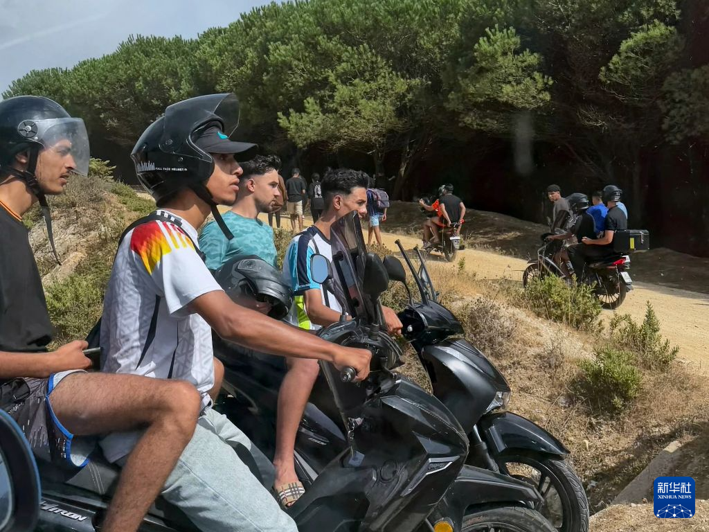7月30日，人们聚集在西班牙北非飞地休达与摩洛哥边境摩洛哥一侧，准备越境进入休达。新华社发（刘文勇摄）